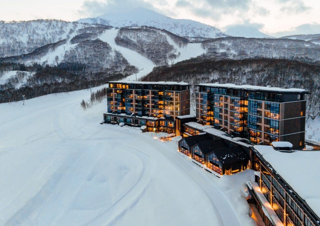 The on-site accommodations at Niseko United, brightly lit at dusk.