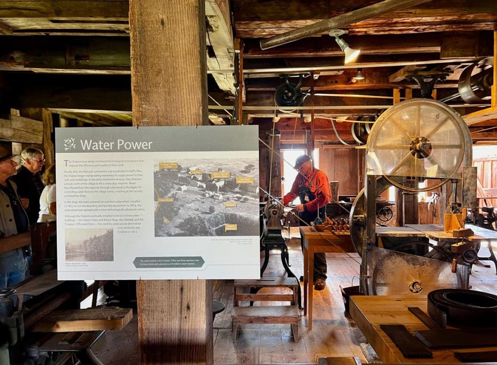 A guide demonstrates the wind turbine used by the Shakers to curious onlookers.