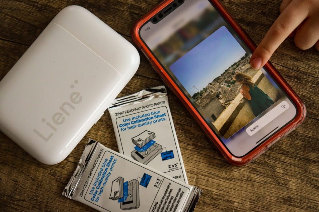 A young girl points to the picture she wants to print using the Liene Pearl Portable Photo Printer.