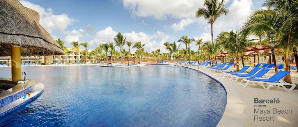 The large pool and surrounding pool deck, with pool-side loungers at Barceló Maya Grand Resort.