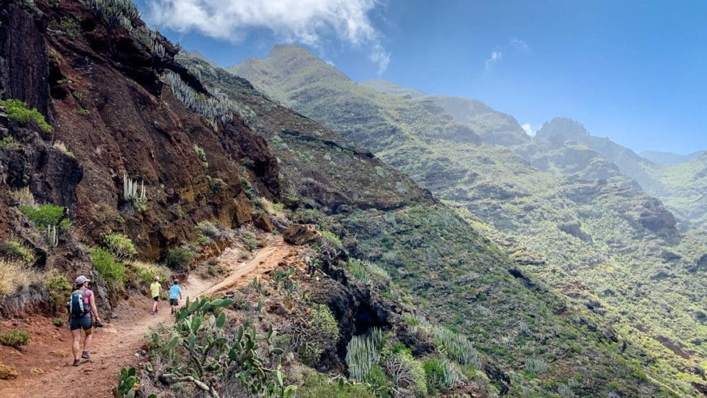 Three people hike along a path in Tenerife.
