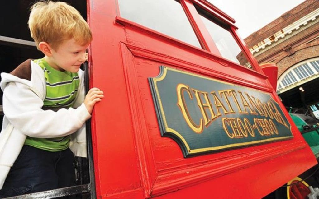 A young boy leans out of a red train at Chattanooga Choo Choo.