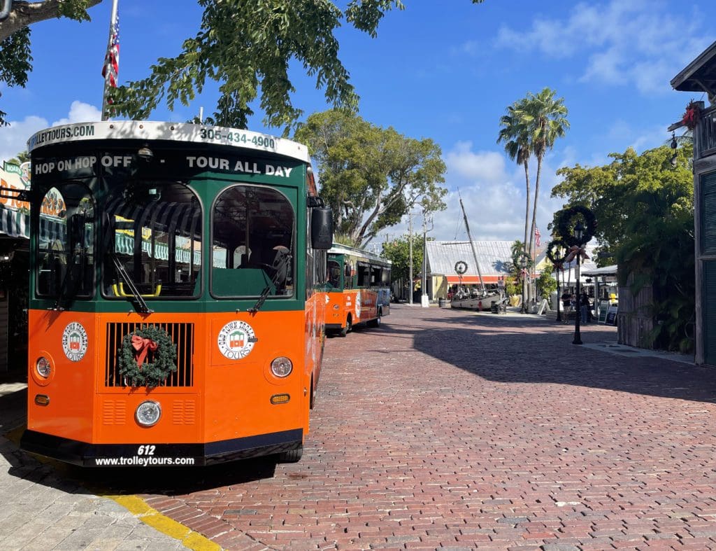 An iconic green and orange street car parked along the side of the road in Key West.