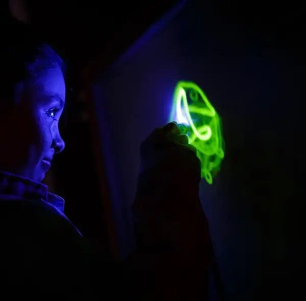 A young child playing at a light exhibit at Mountain Top Explorium.