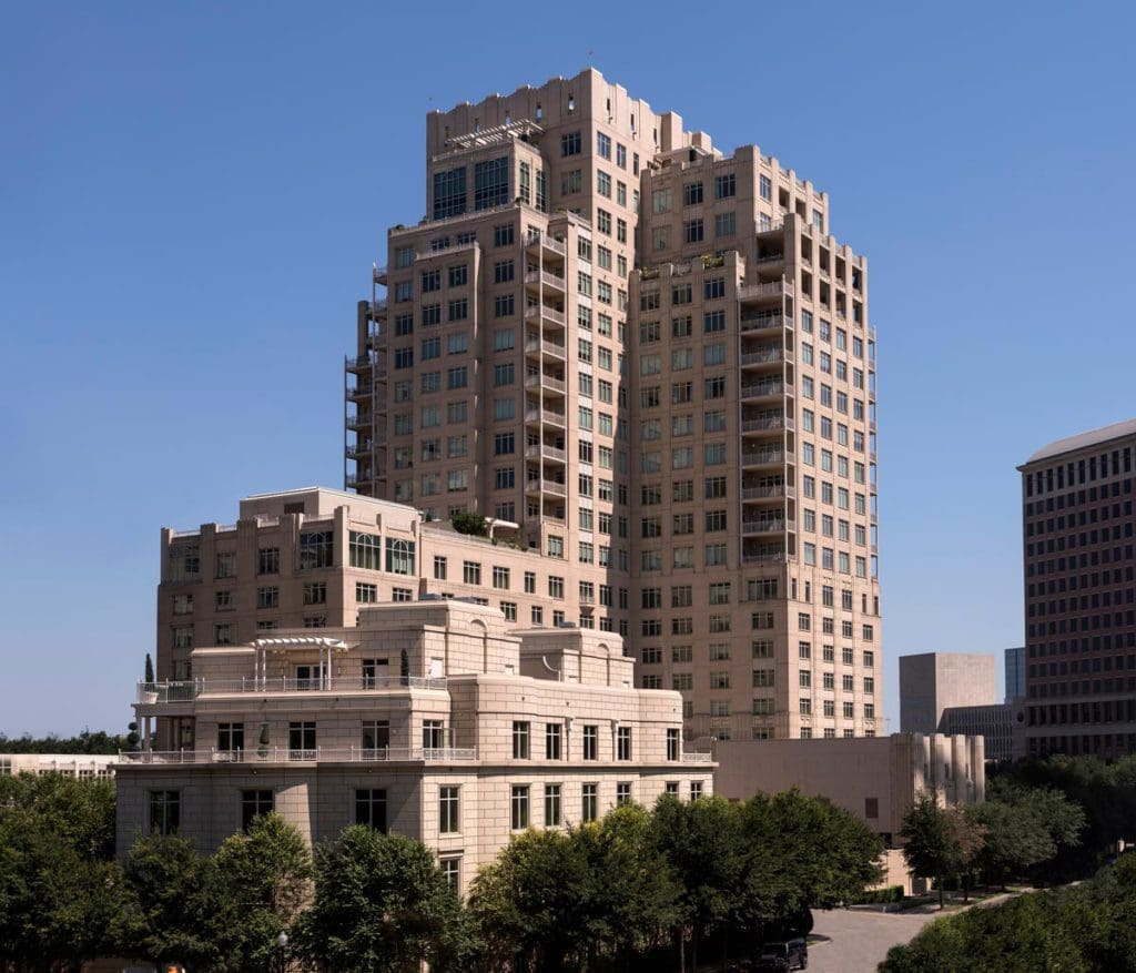 The exterior of The Ritz-Carlton, Dallas, rising above the tree-line on a sunny day, one of the best hotels in Dallas for families.