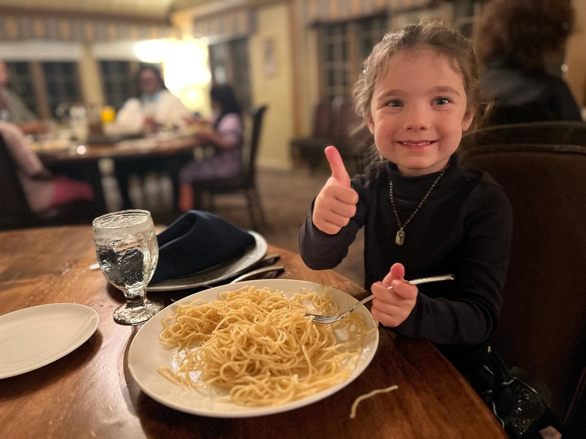 A young girl gives a big thumbs up to a bowl of spaghetti at UCLA Lake Arrowhead Lodge.