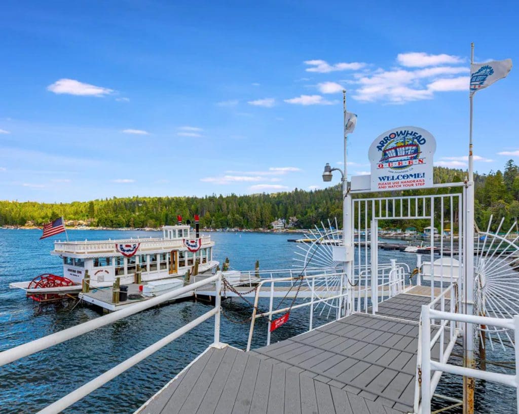 A dock leads toward the Lake Arrowhead Queen, a boat that embarks on Lake Arrowhead and offers scenic views.