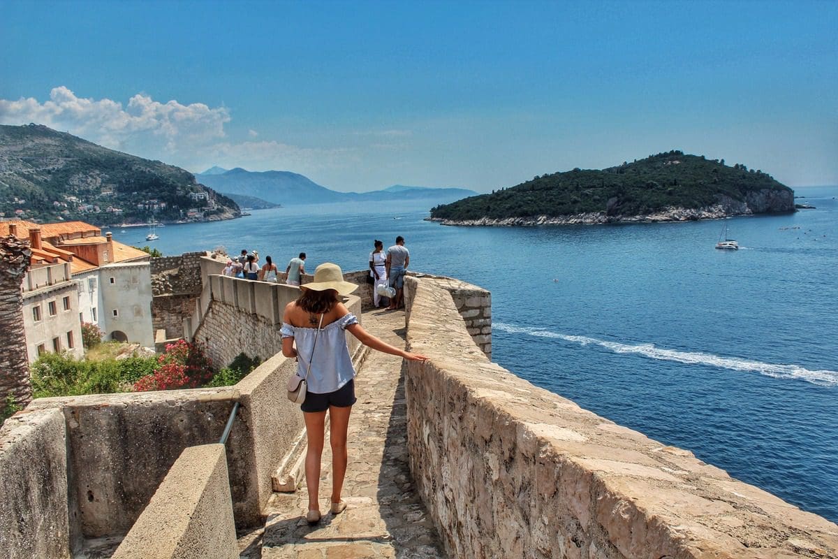 Several people walk along the Old Town Wall of Dubrovnik, one of the best places to visit in Croatia with kids this summer.