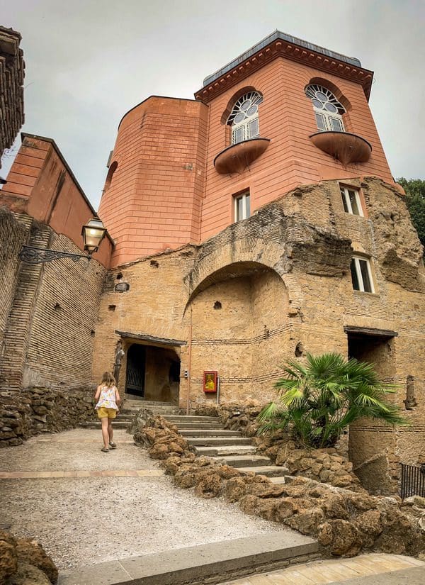 A young girl climbs the stairs of one of the small museums at Musei di Villa Torlonia, one of the best museums in Rome with kids.