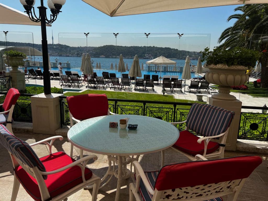 A sunny patio facing a pool at Ciragan Palace Kempinski, one of the best hotels in Istanbul with kids.