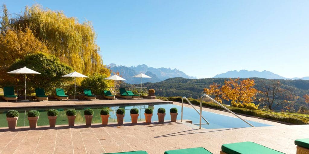 The outdoor pool overlooking the mountains at Parkhotel Holzner, one of the best all-inclusive resorts In Italy for families.
