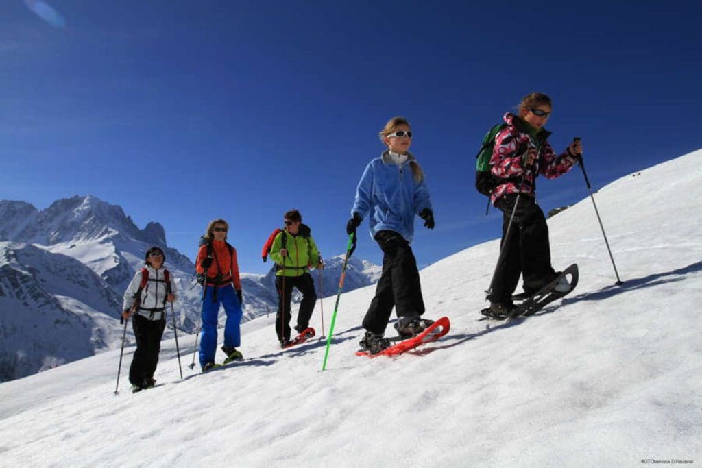 Five people snowshoe across the snow near Chamonix. 