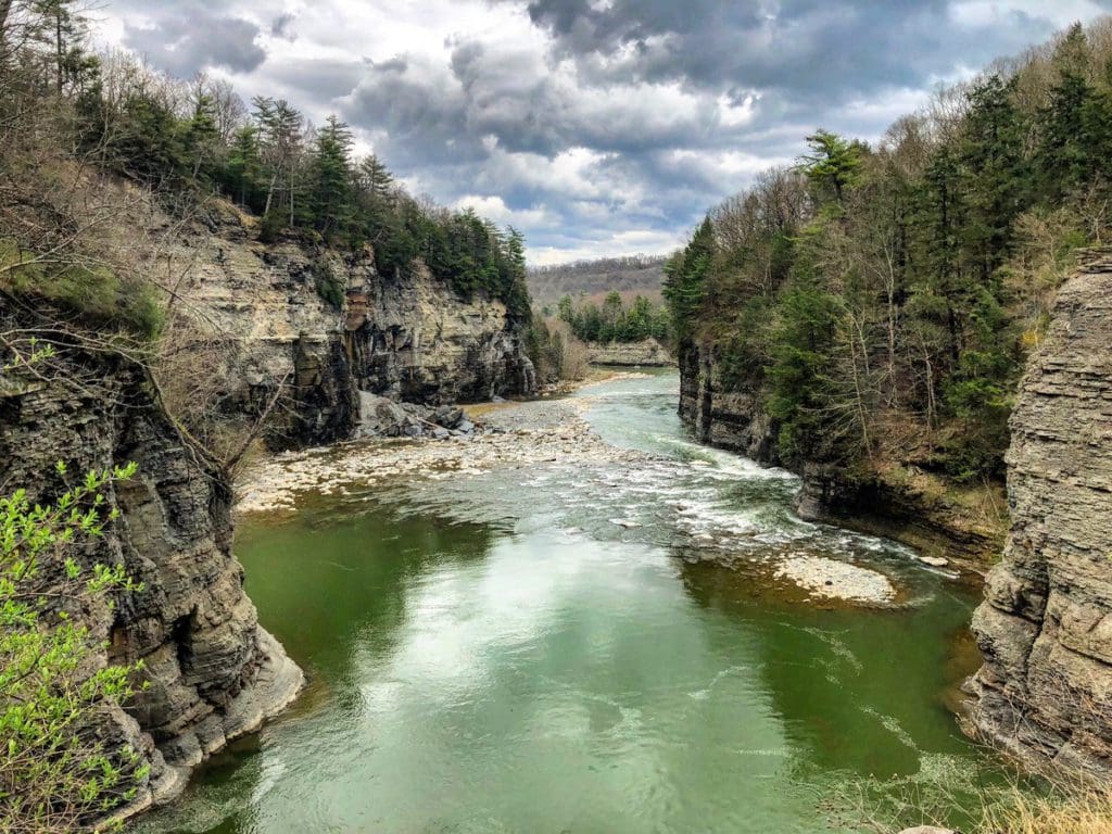 A gorge with a river flowing through from the Lower Falls inside Letchworth State Park, within the Finger Lakes region of New York, one of the best places to visit during Memorial Day Weekend near NYC for families.