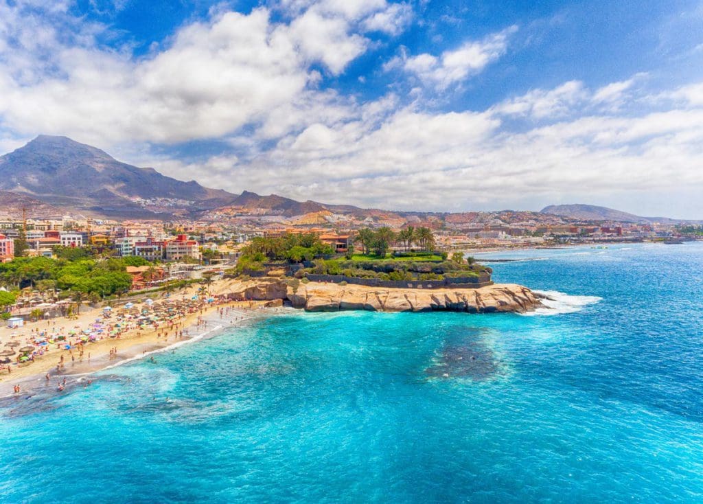 An aerial view of the coastline and beach of the Canary Islands, one of the best hot places to visit in December for families.