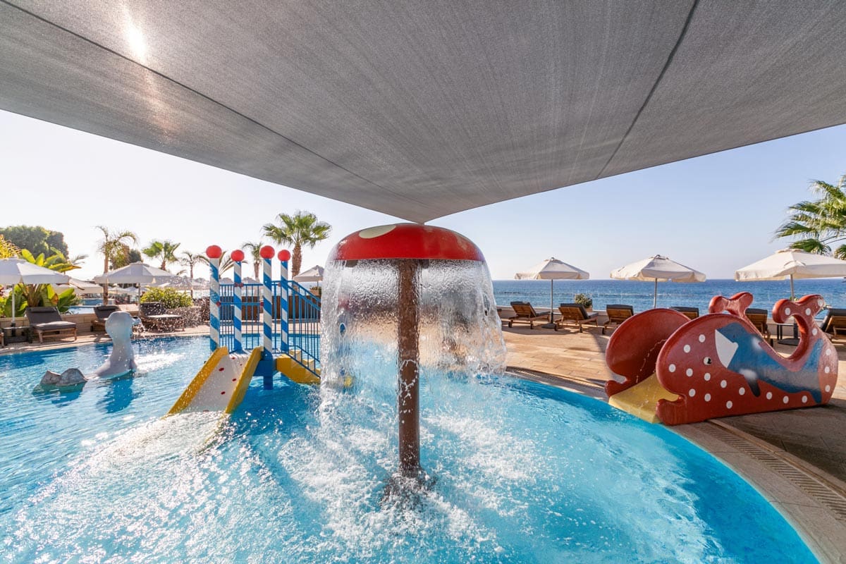 The entertaining kids' pool with a splash area and small slides at The Royal Apollonia.