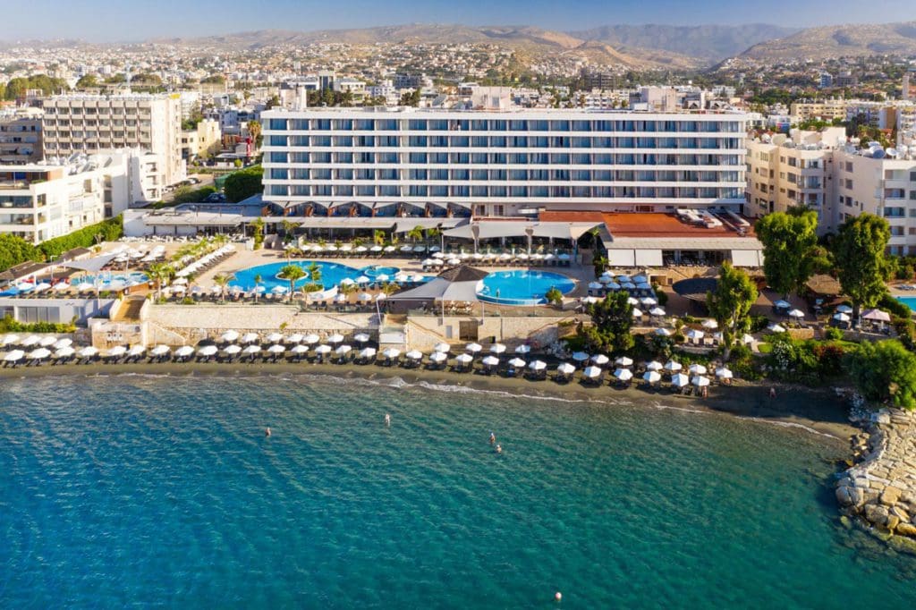 A view of  The Royal Apollonia from the sea, with an expansive beach in Cyprus, one of the best all-inclusive resorts in Cyprus for families.