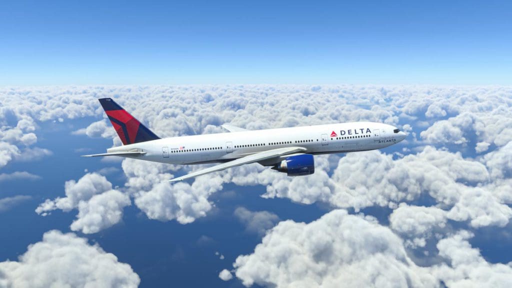 A Delta Airlines plane flights over fluffy white clouds.