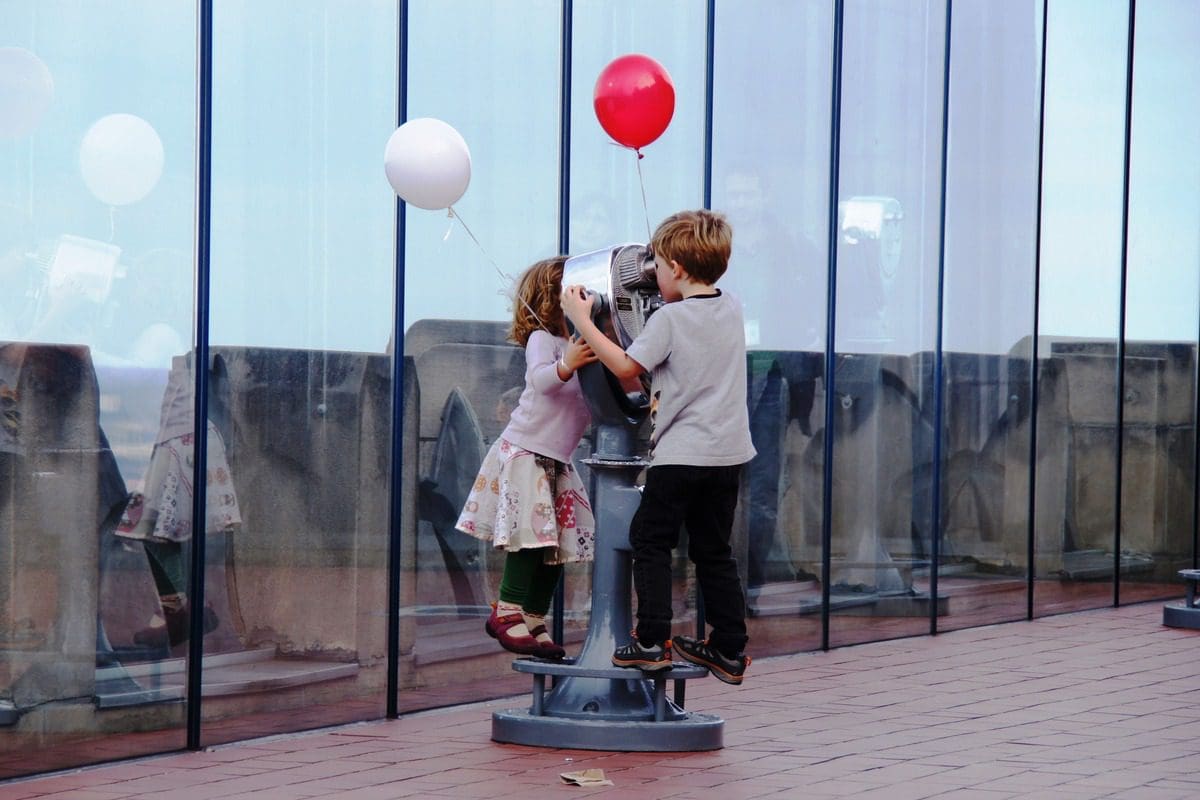 Two kids with balloons explore the Top of The Rock at Rockefeller Plaza in NYC.