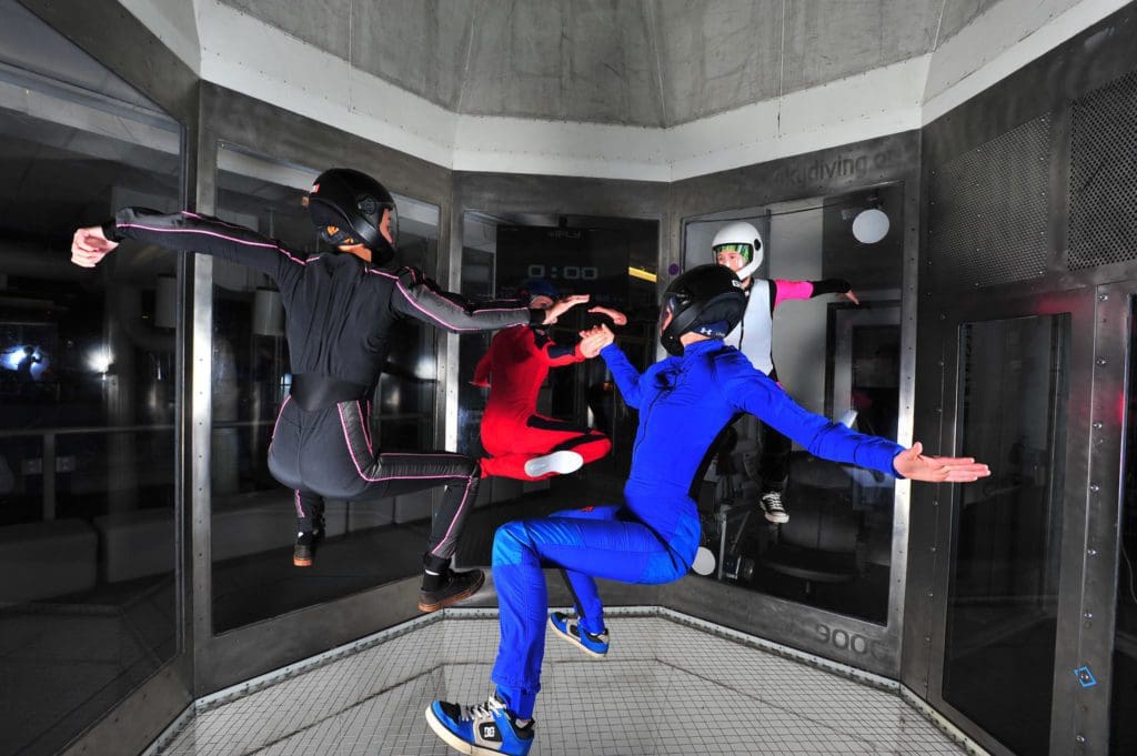 Three people float in a "flying" experience at IFly Denver.