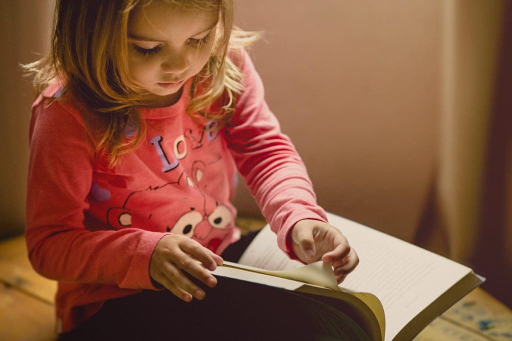 A young girl reads quietly to herself.