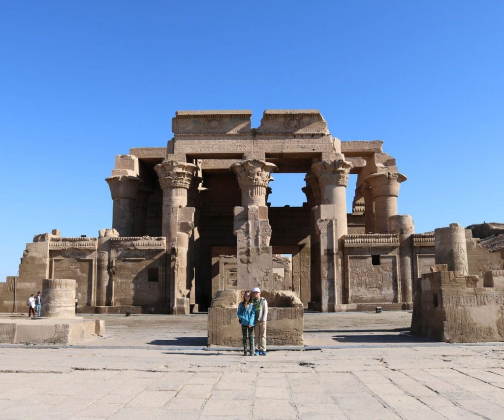 Two kids stand together in front of ancient ruins in Luxor, Egypt.