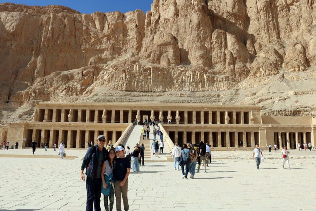 A family of four poses together in front of the Valley of the Kings, near Luxor.