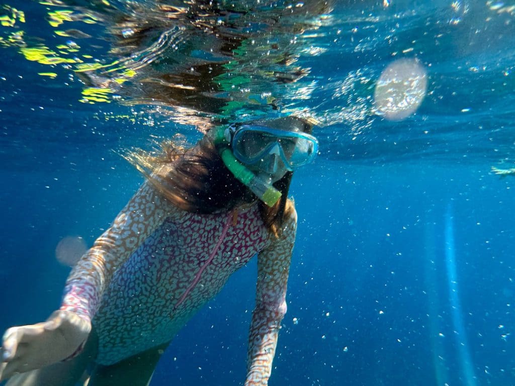 A young girl snorkels in the waters of Sharm el-Sheikh, a must on this 2-Week Egypt Itinerary for Families.