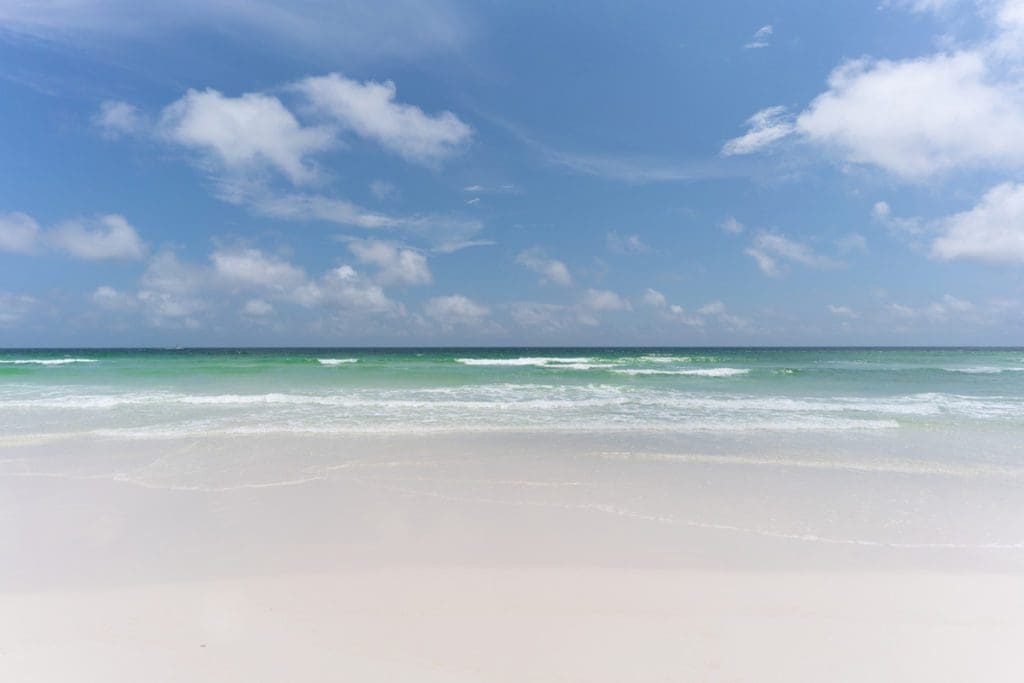 White sandy shore of Alys Beach with soft waves crashing.