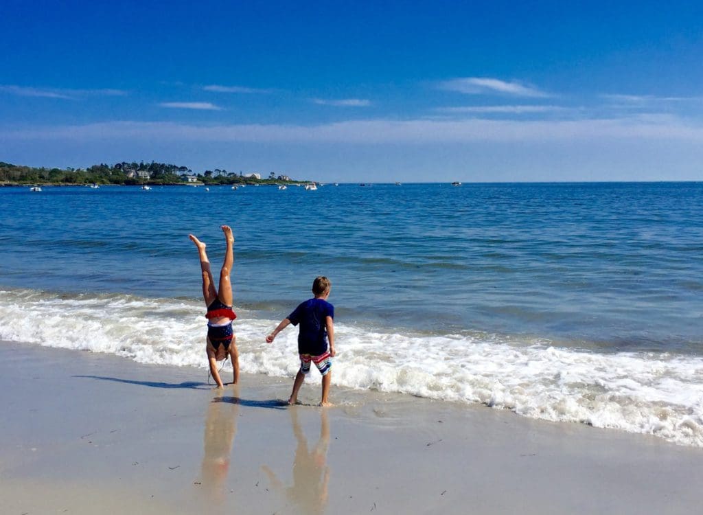 Two kids play on the beach, while staying at Inn by the Sea, one of the best Maine hotels for families.