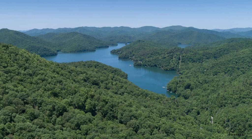 An aerial view of Nantahala Lake, with lush trees surrounding the lake during the summer.