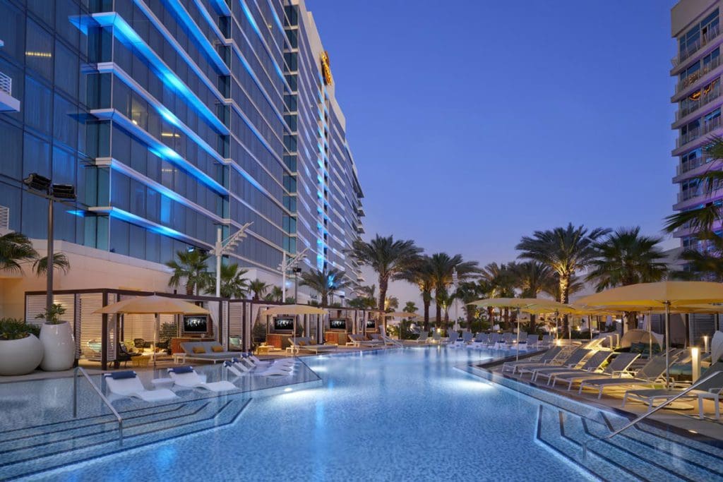 The outdoor pool at Seminole Hard Rock Hotel & Casino Tampa, one of the best hotels in Tampa Bay for families, lit up at night.