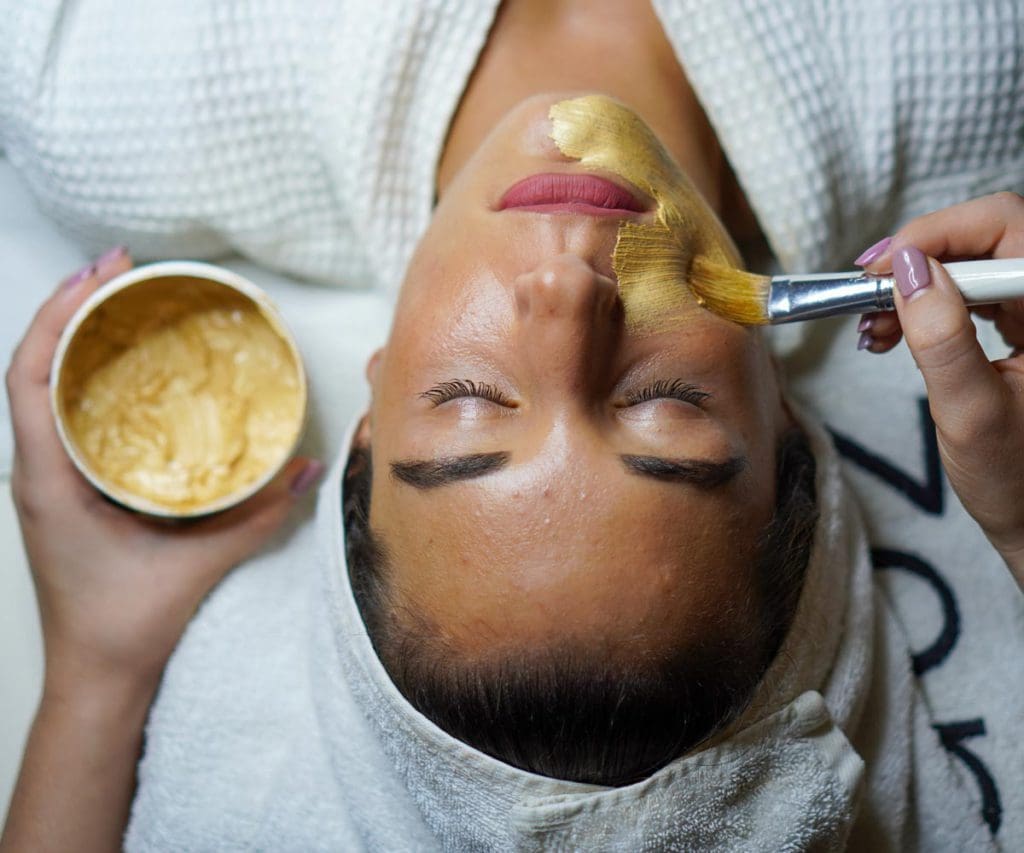 A woman receives a facial treatment at a spa.