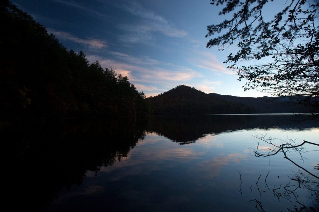 Lake Santeetlah, surrounded by mountains, at dusk.