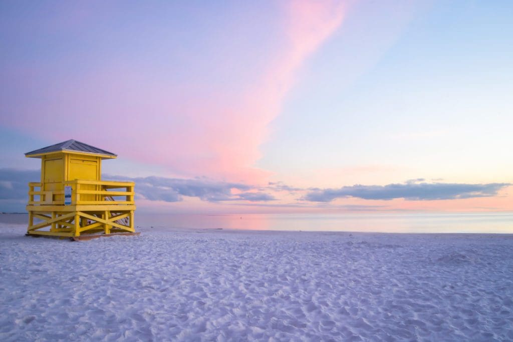A yellow lifeguard post facing the sunset at Siesta Key Beach in Sarasota County, one of the best Florida beaches for families.