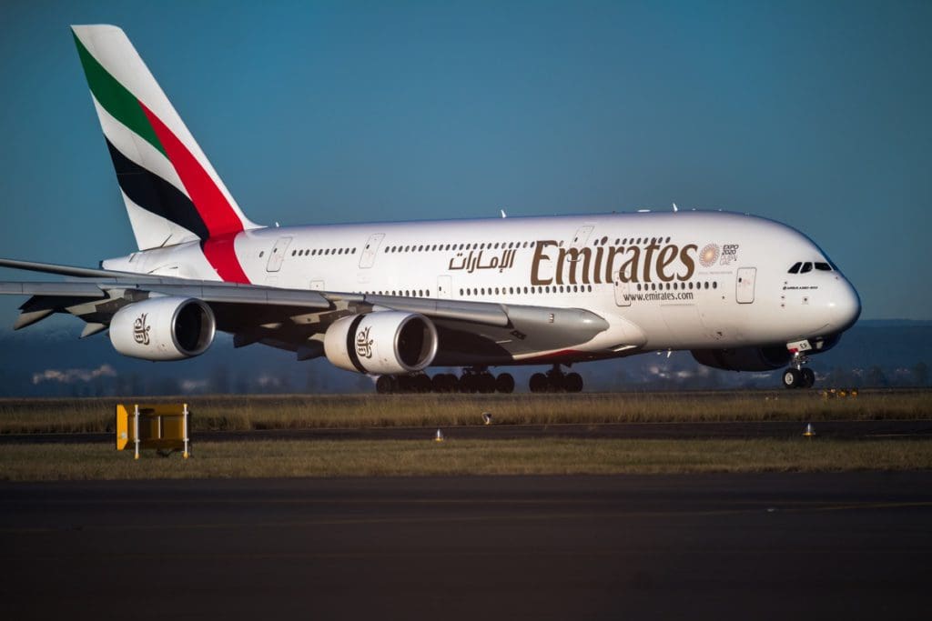 An Emirates plane parked on a jetway.