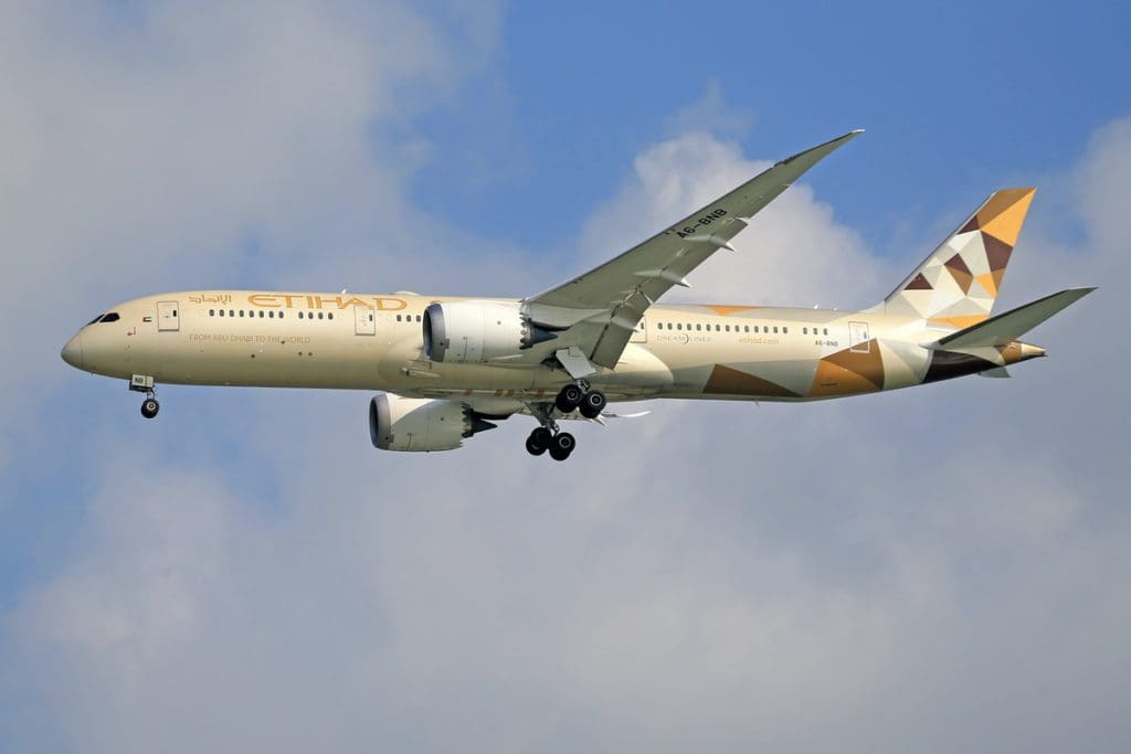 A Etihad Airways plane in flight amongst the clouds.