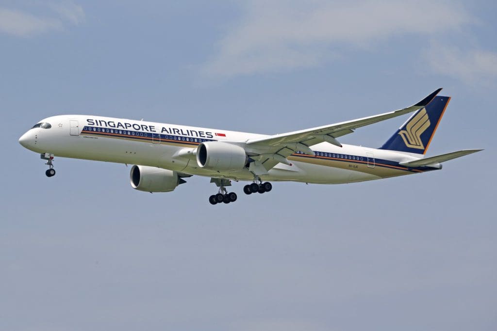 A Singapore Airlines plane in flight amongst the clouds.