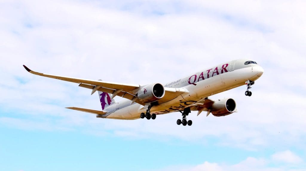 A Qatar Airways plane taking off into the clouds.