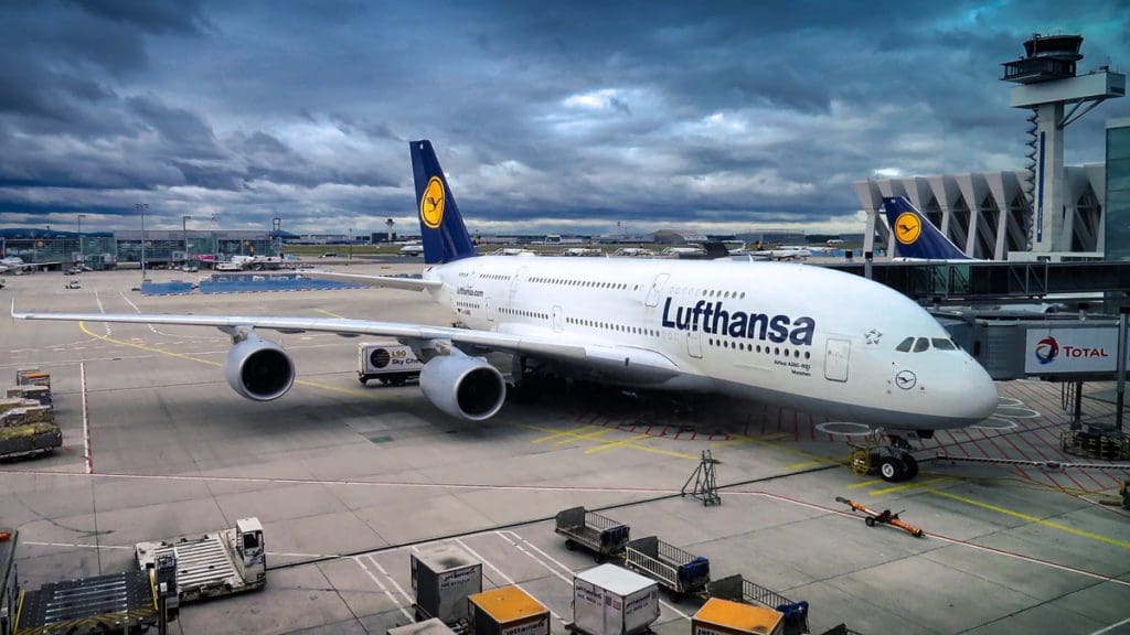 A Lufthansa plane parked at an airport gate.