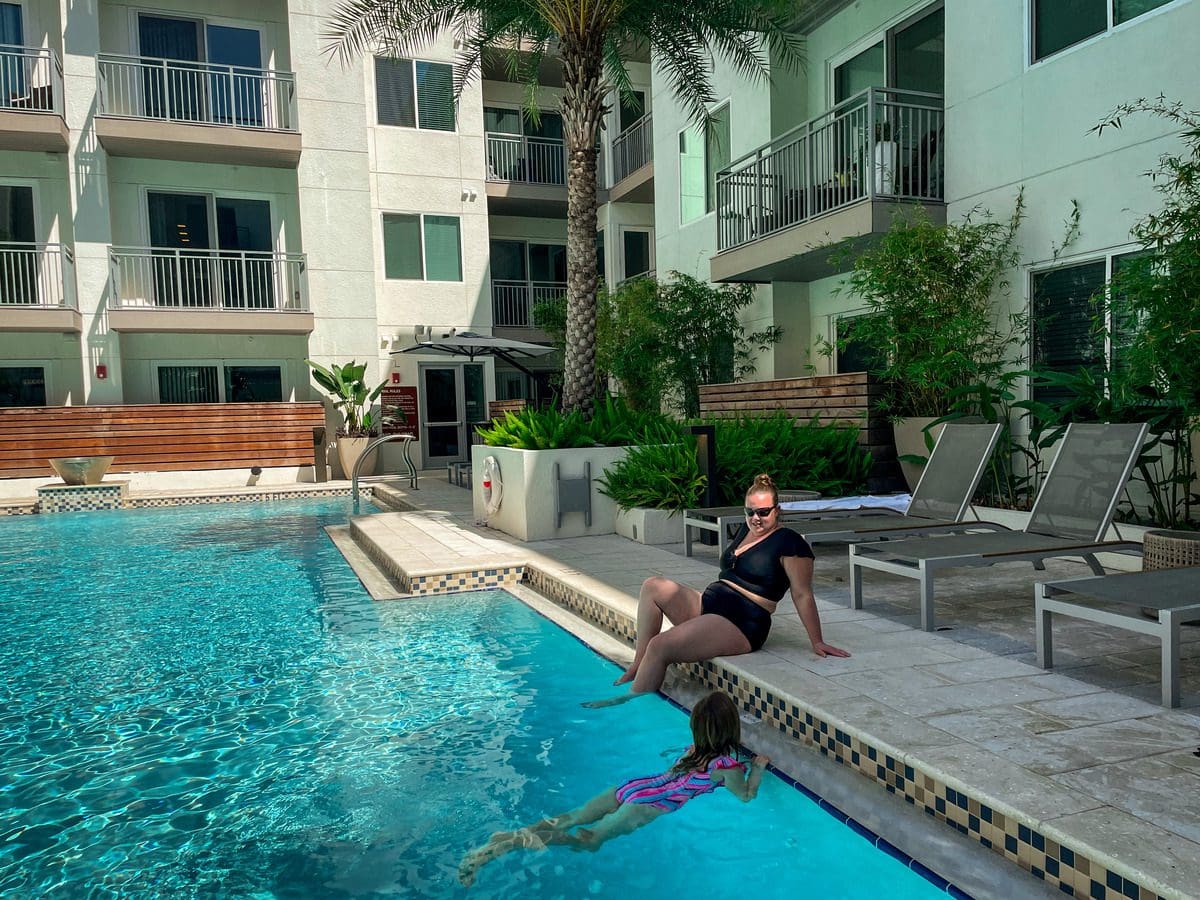 A mom and her young daughter enjoy a sunny day at the pool.