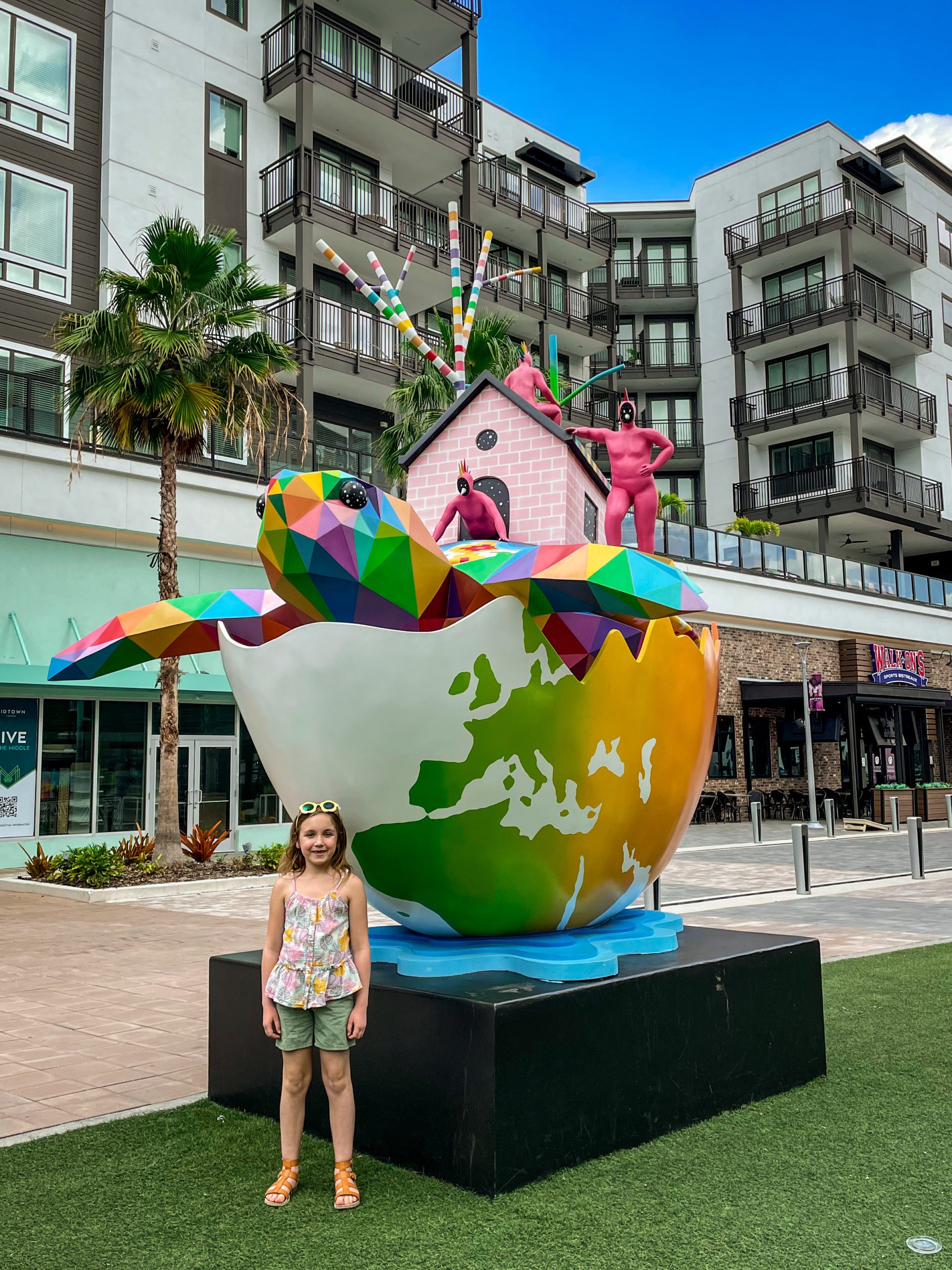 A young girl stands in front of a turtle art installation in the park in the Midtown Tampa neighborhood.