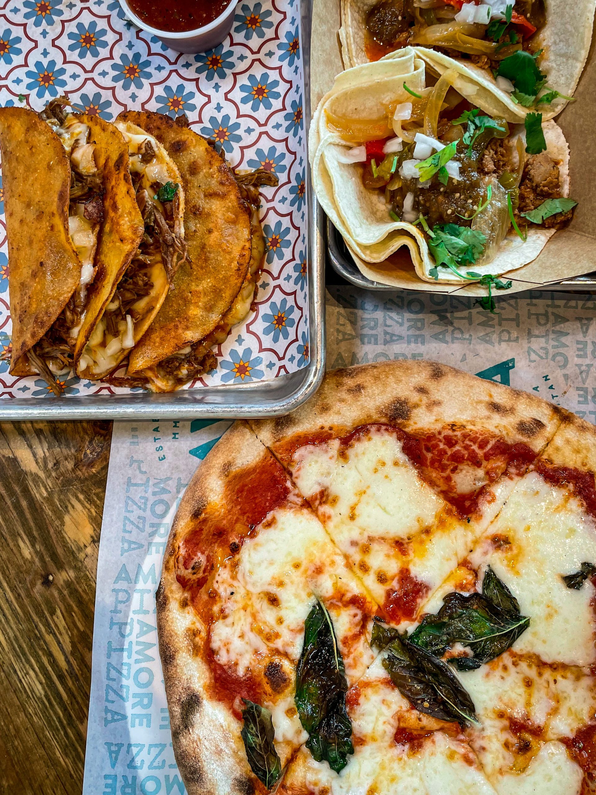 A table spread of pizza and tacos at Armature Works in Tampa Bay.