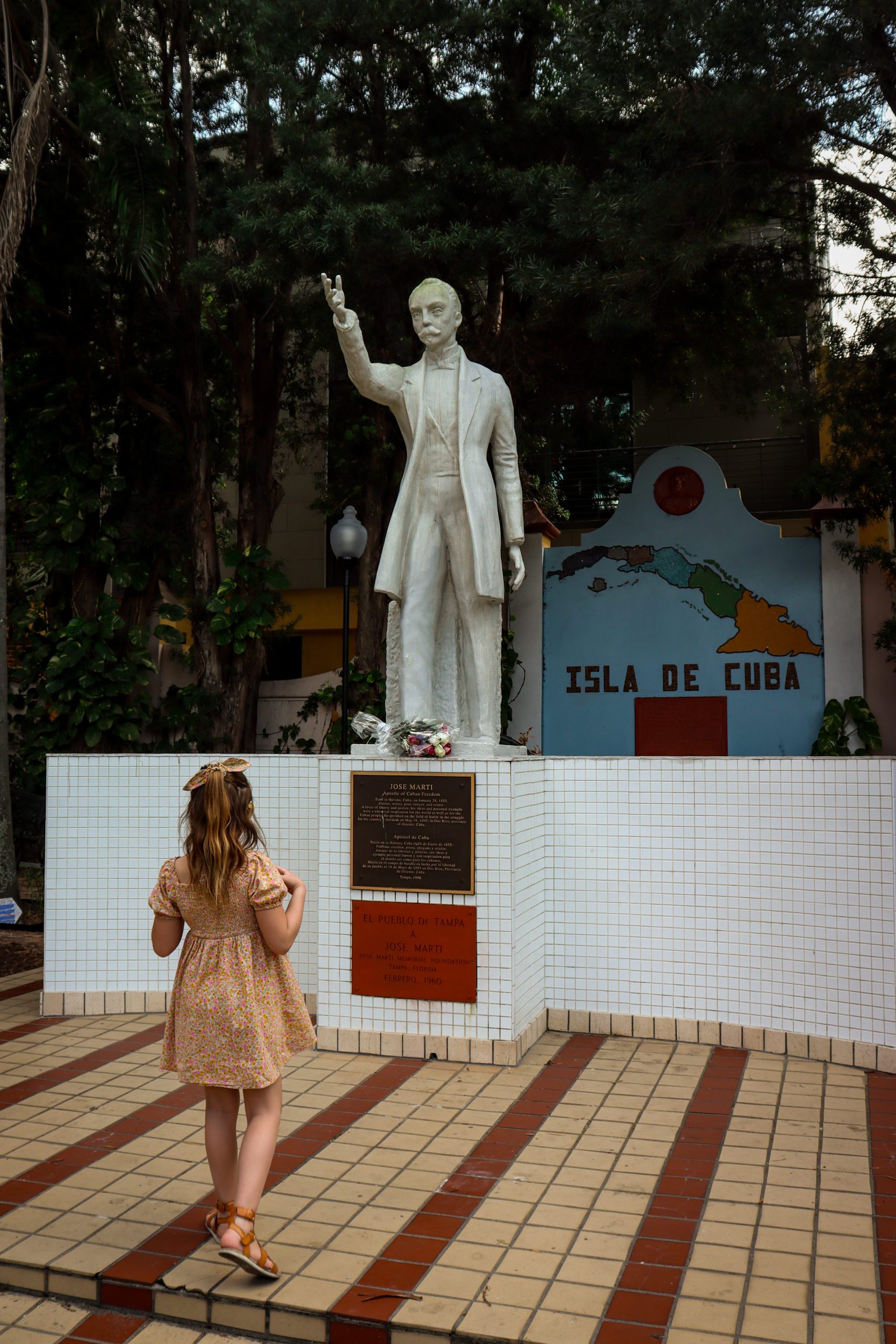 A young girl looks at a statue of Jose Marti in his namesake park in Ybor City, a must do when you visit Tampa Bay with Kids.