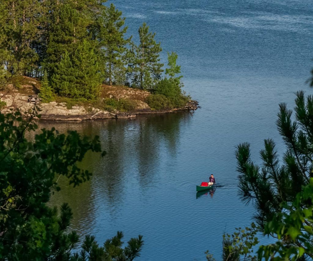 A canoe moves across smooth waters while exploring Burntside Lake.