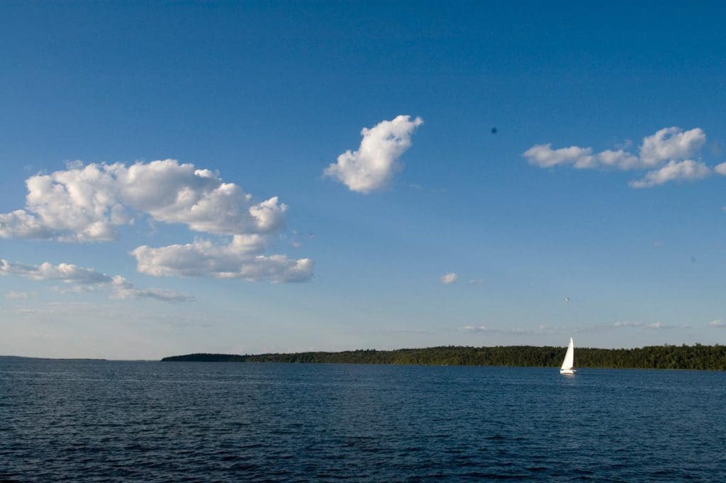 A sail boat moves across Leech Lake on a sunny day on one of the best lakes in Minnesota for families.