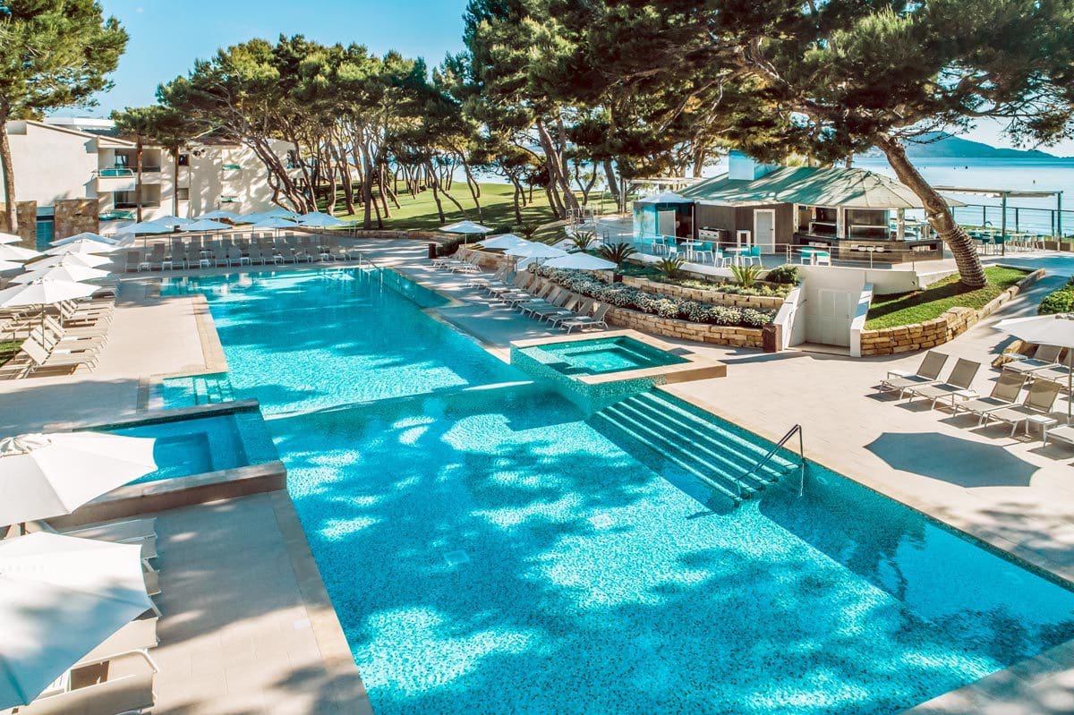 An aerial view of the lovely pool and surrounding pool deck at Iberostar® Selection Playa de Muro, one of the best all-inclusive hotels in Mallorca for families.