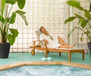 A mom relaxes in the spa, surrounded by lush greenery, at Lansdowne Resort.