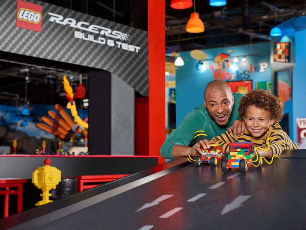 A dad and his young son play with a lego race track at Legoland Discovery Center (Chicago).