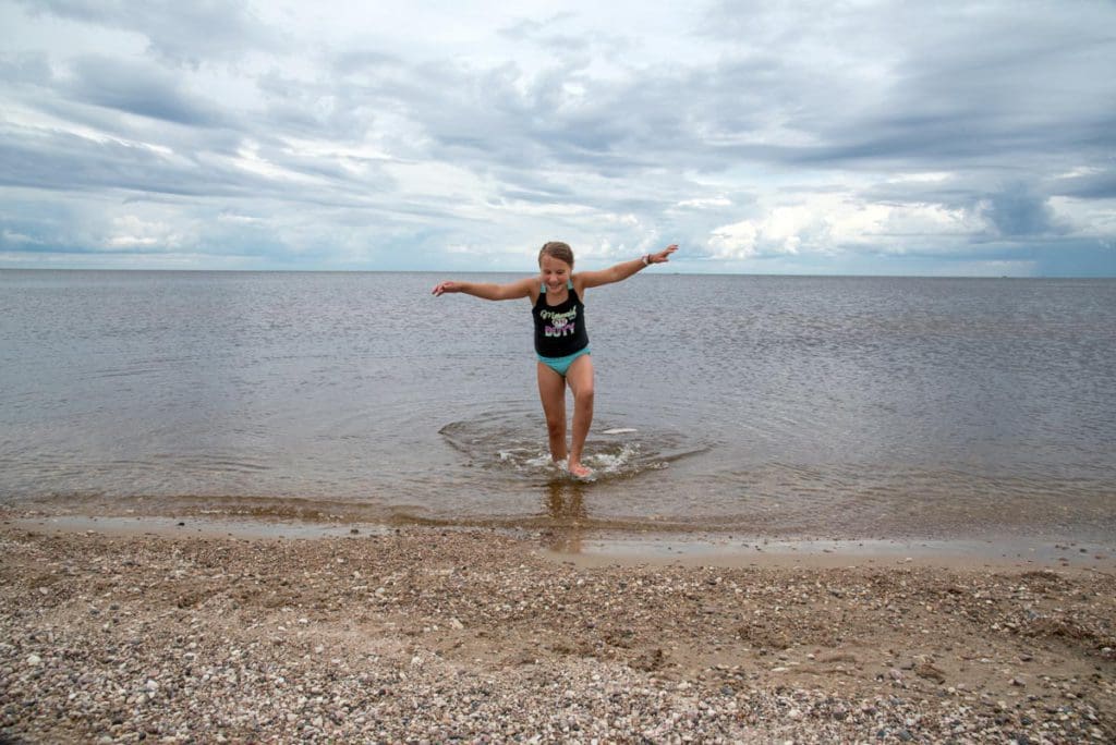 A young girl runs along the shores of Lake of the Woods.