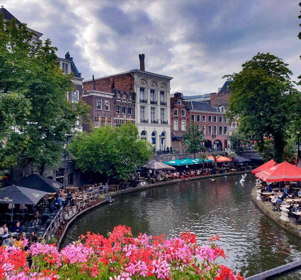 Cafe tables filled with people line the canal of Utrecht, one of the best places to visit in the Netherlands with kids.